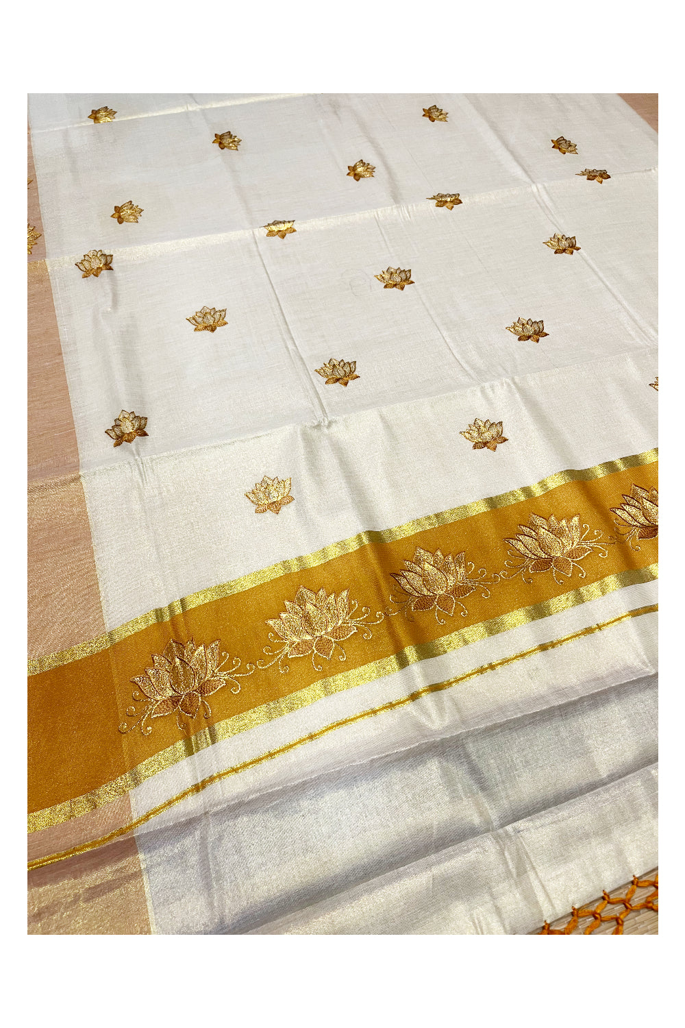 Southloom Kerala Tissue Kasavu Saree with Saffron And Golden Lotus Embroidary Designs on Body