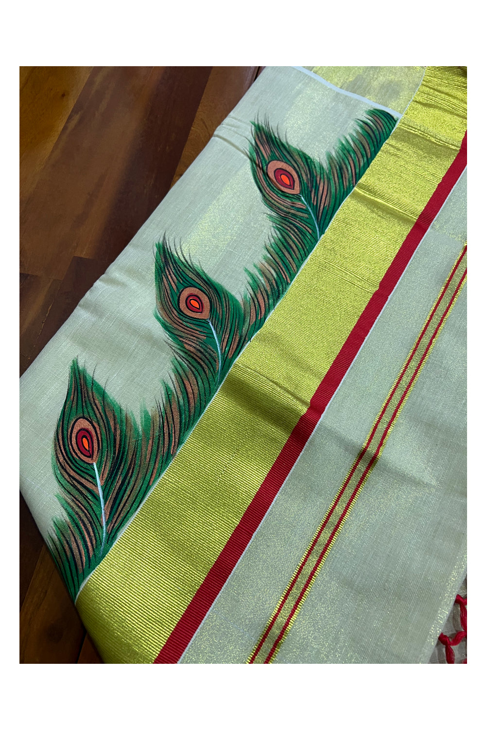 Kerala Tissue Kasavu Saree with Hand Painted Feather Design and Red Tassels Work